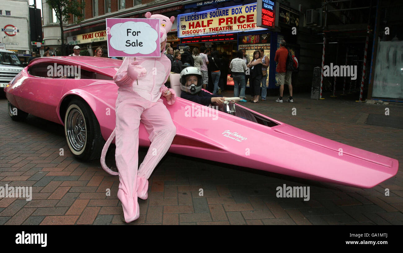 A man dressed as the Pink Panther holds a for sale sign as eight year old Beth Rutledge sits at the wheel of the 1969 Pink Panther car to Leicester Square in London to take part in the 'West End Live' event. Stock Photo