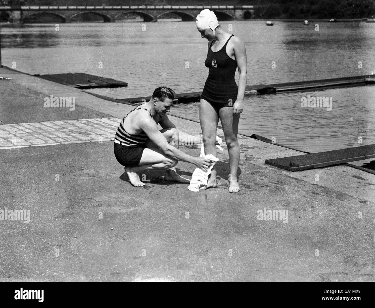 Miss Eva Coleman, who intends to attempt the Channel swim this summer, is using the Hyde Park Lido as a training ground. Her trainer, Burgess, considers she has a good chance of breaking the record set up by Gertrude Ederle. Picture shows Miss Eva Coleman receiving a towelling down from her trainer, Burgess, after her swim Stock Photo