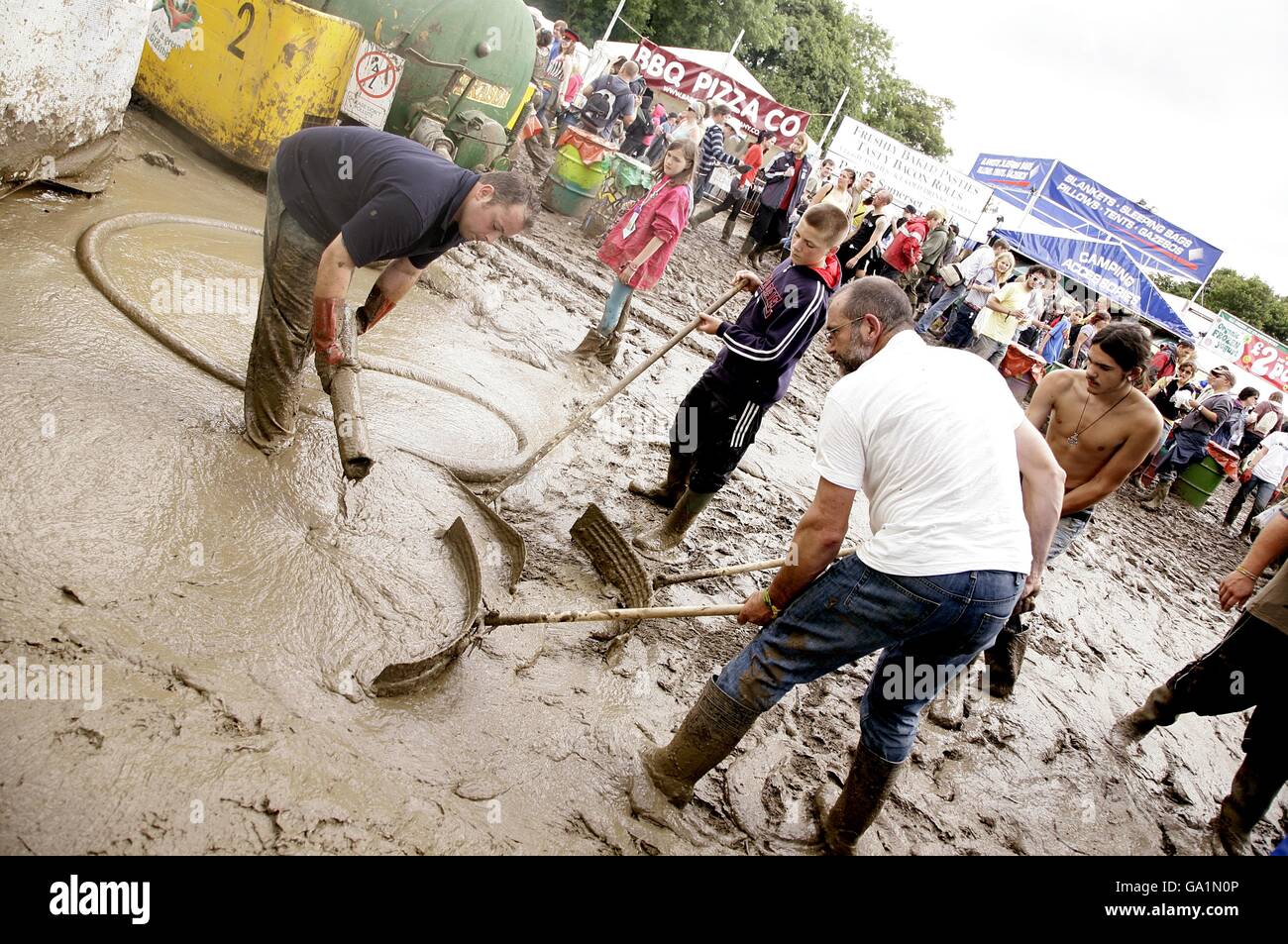 Festival staff try the best to dry out the ground at the 2007 Glastonbury Festival at Worthy Farm in Pilton, Somerset. Stock Photo