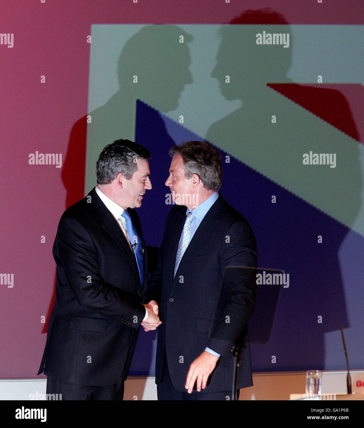Gordon Brown and Tony Blair shake hands on stage at the special Labour