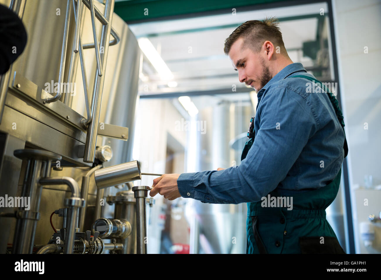Brewer checking beer at brewery Stock Photo