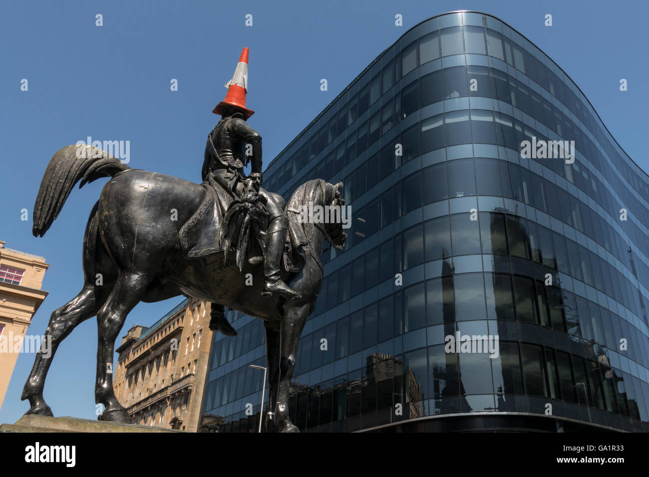 Statue of Duke of Wellington with traffic cone on head, facing modern office block, Glasgow, Scotland, UK, Stock Photo