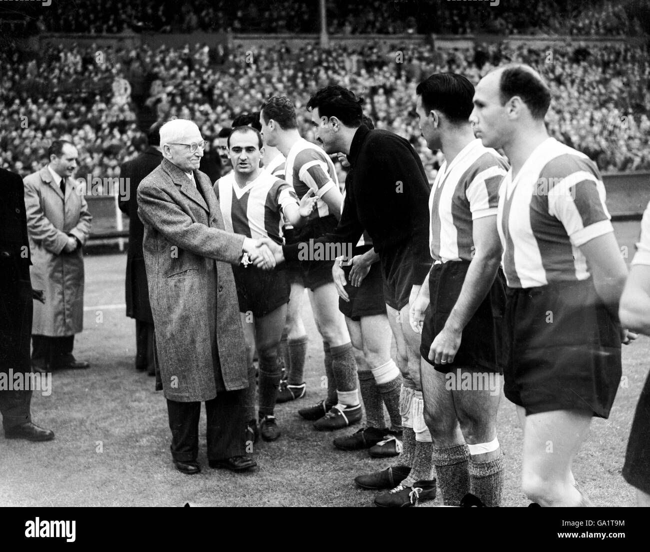 Originator of the World Cup, Frenchman Jules Rimet (l), shakes hands with Argentina goalkeeper Miguel Rugilo (third r) as the teams are introduced to him before the match Stock Photo