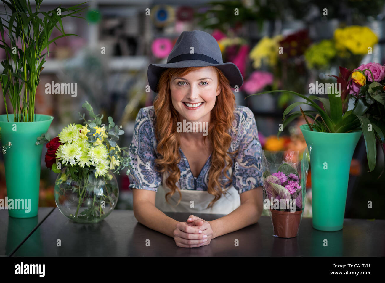 Happy female florist leaning in flower shop Stock Photo - Alamy