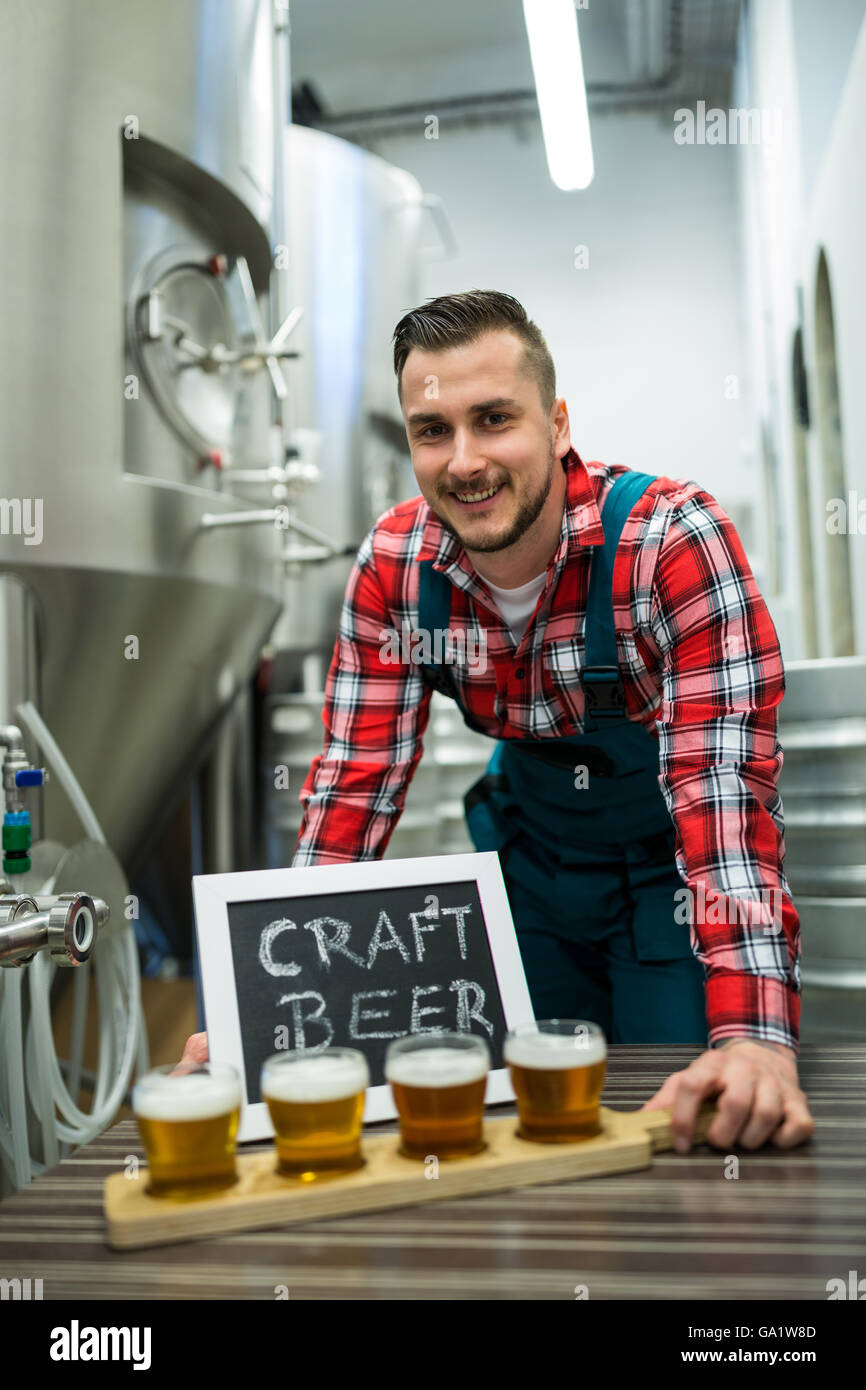 Portrait of brewer with four glasses of craft beer on table Stock Photo