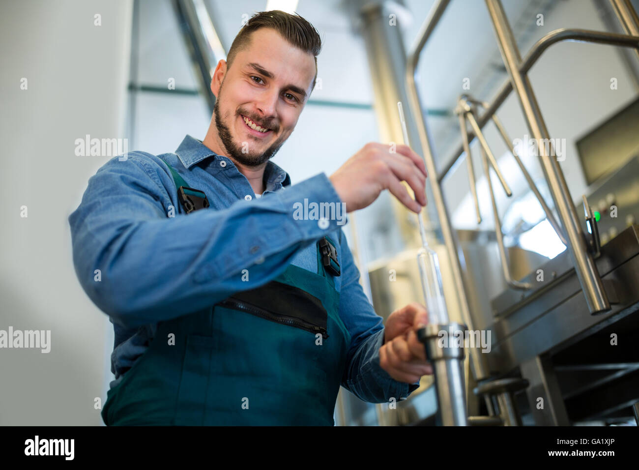 Brewer checking beer with hydrometer Stock Photo