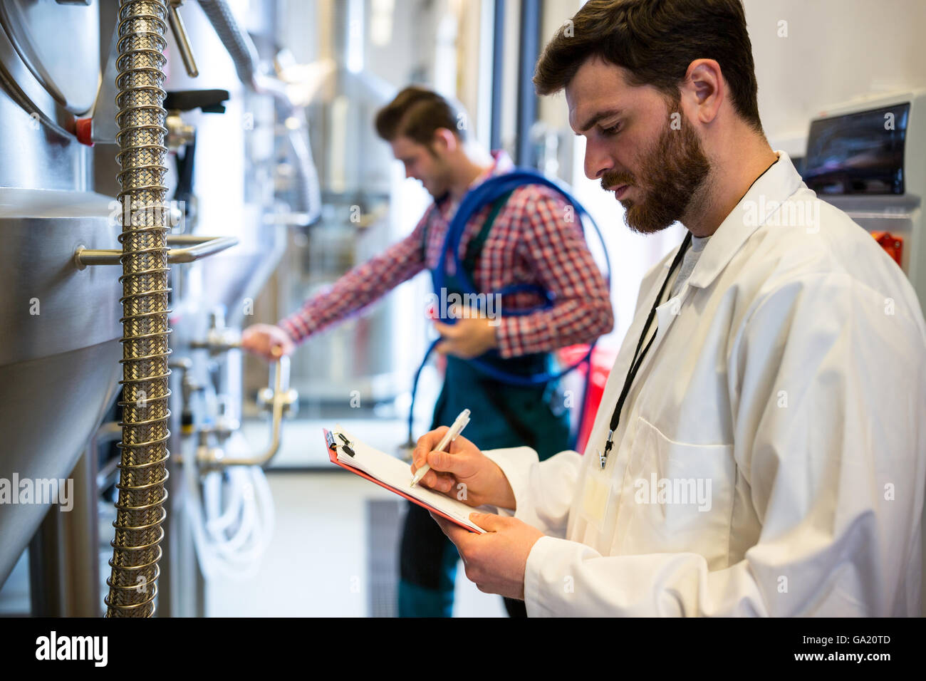Maintenance workers examining brewery machine Stock Photo Alamy