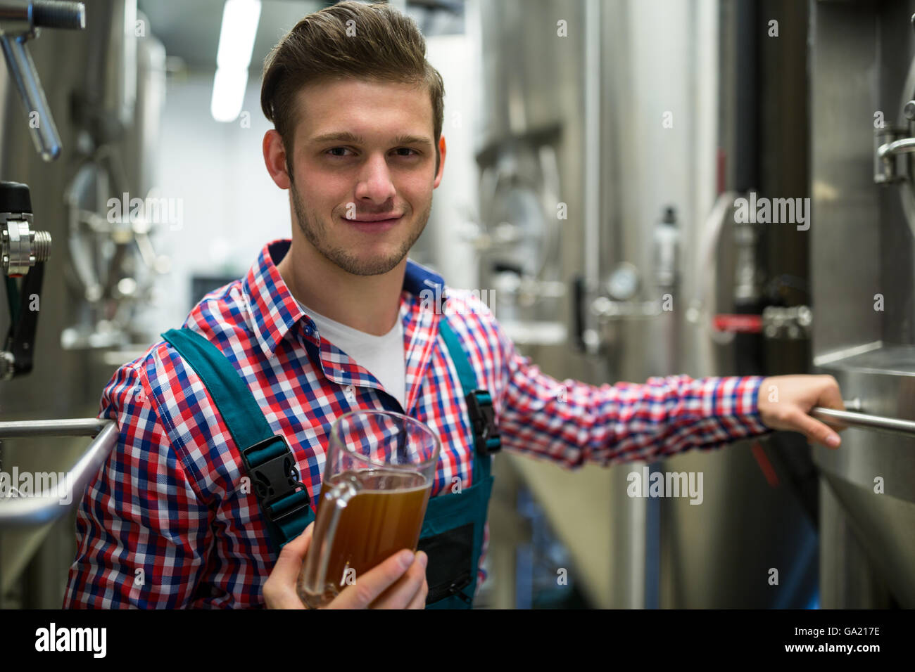 Brewer holding pint of beer Stock Photo