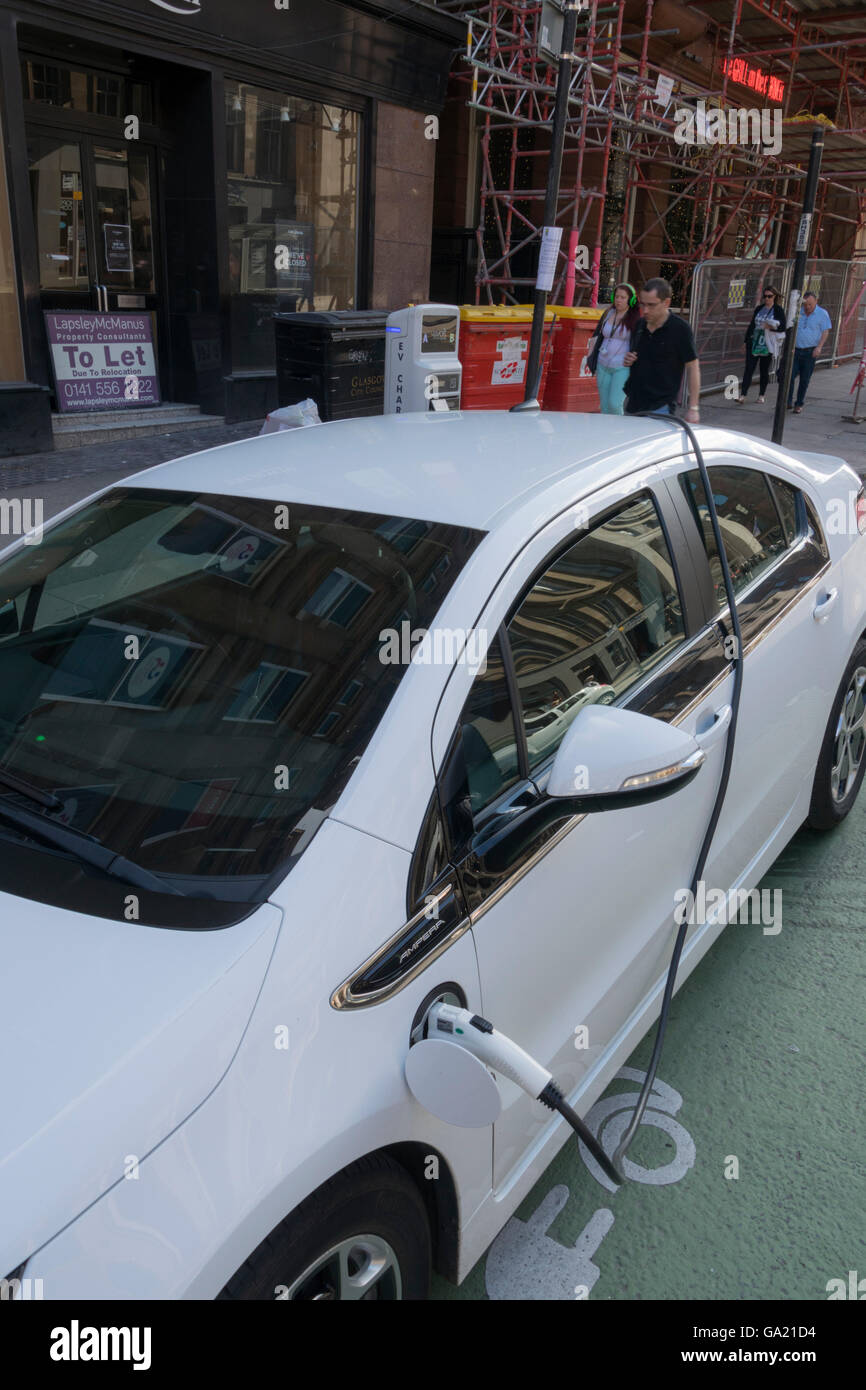 Electric vehicle parked at city centre street charging station, Glasgow