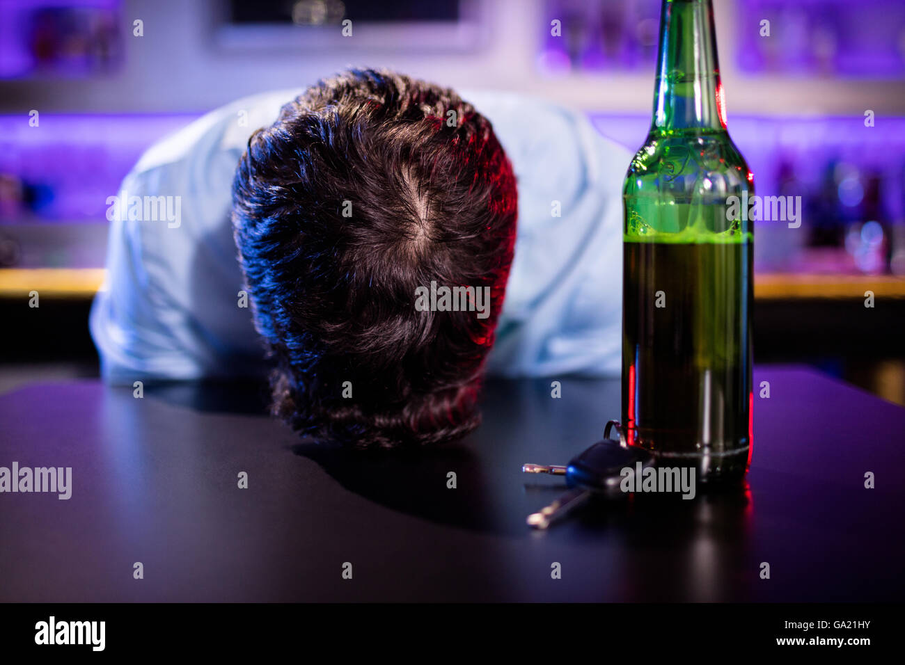 Depressed drunk man sleeping with his head on the table Stock Photo - Alamy