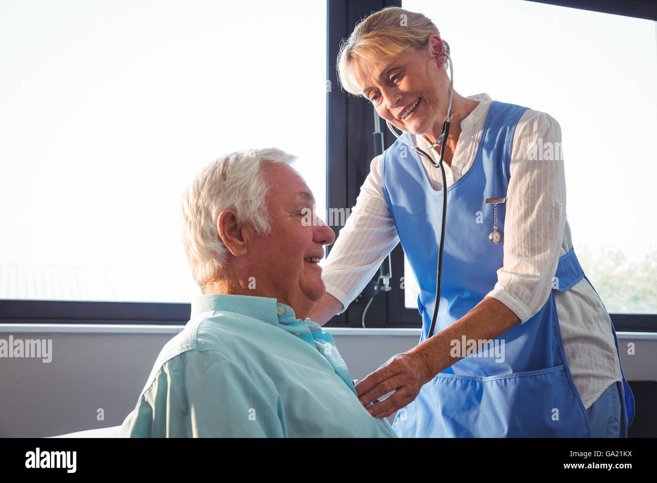 Nurse using stethoscope to take care of a senior man Stock Photo - Alamy