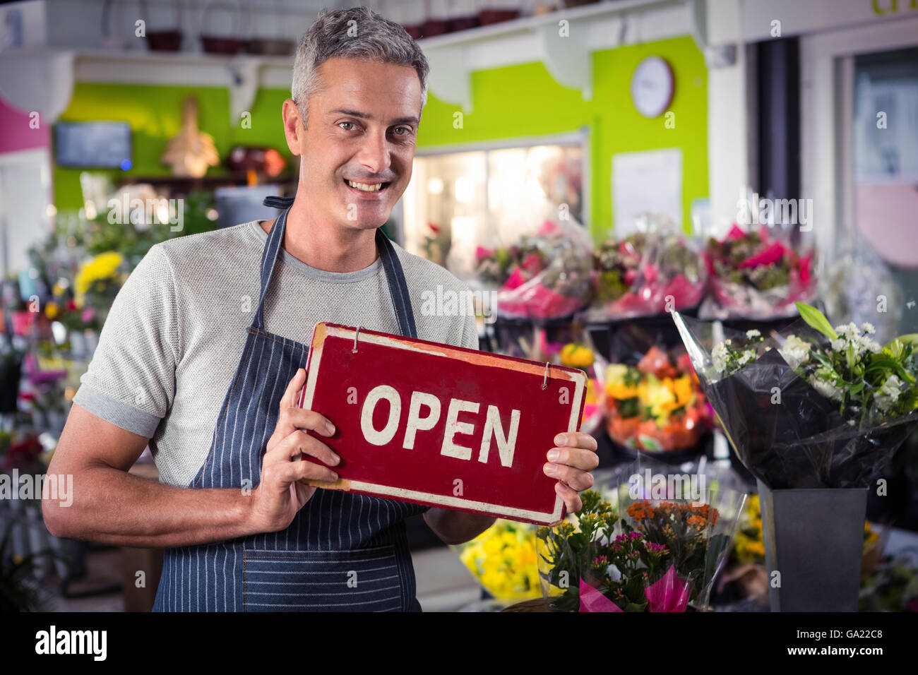 Male florist holding open signboard Stock Photo Alamy