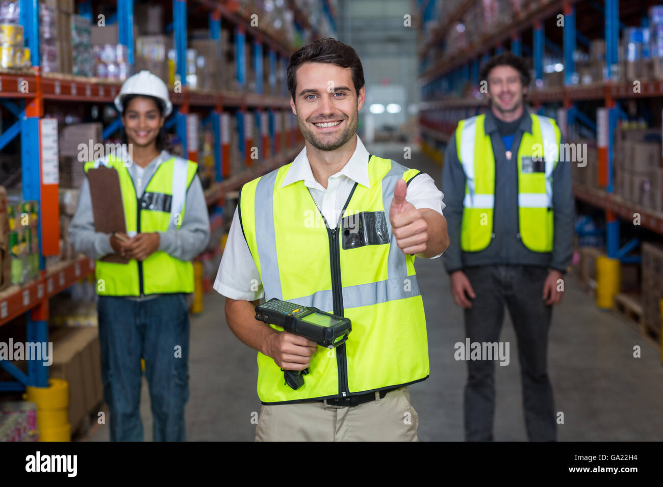 Worker with thumb up wearing yellow safety vest Stock Photo