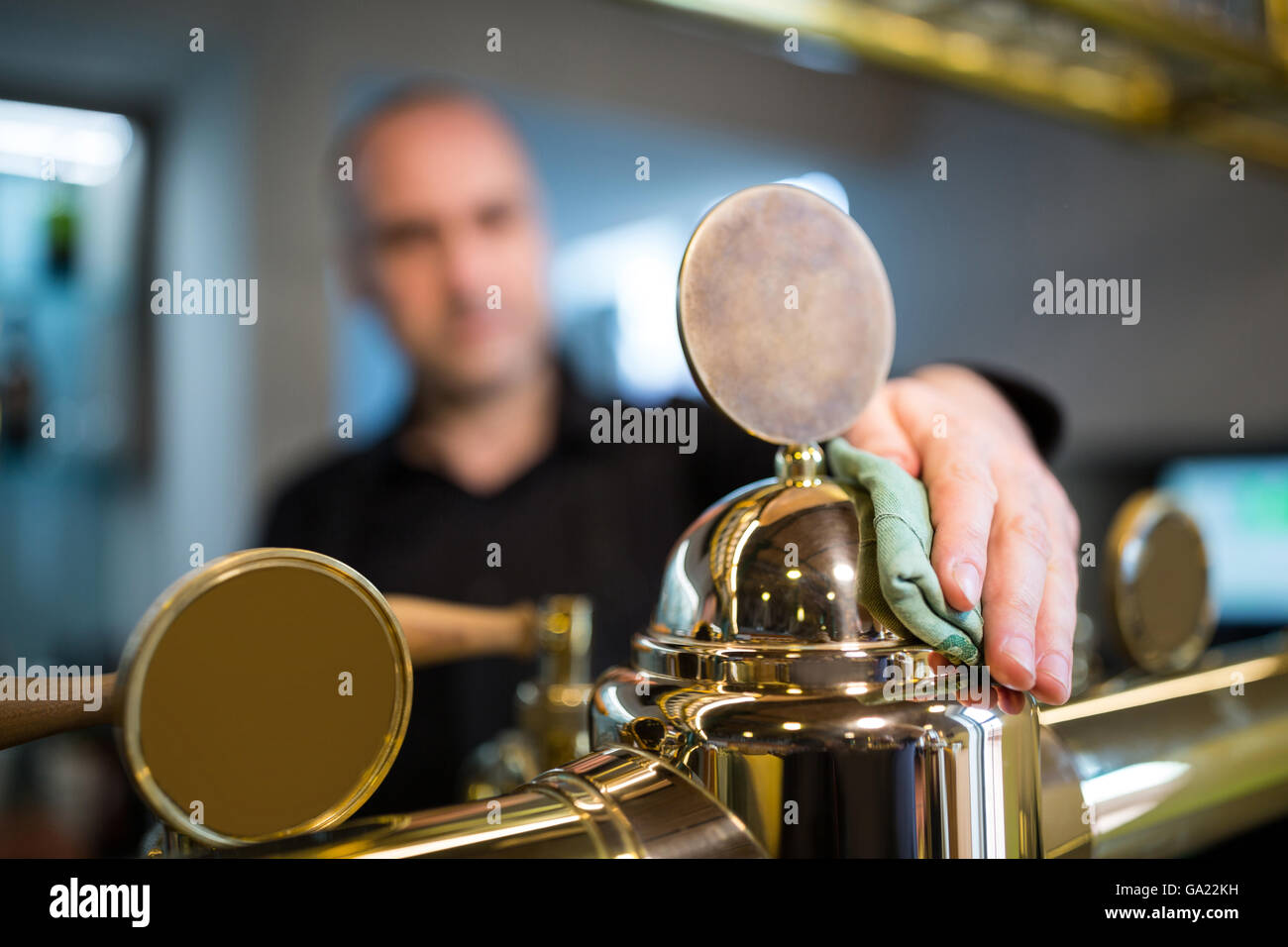 Bar tender cleaning beer pump Stock Photo