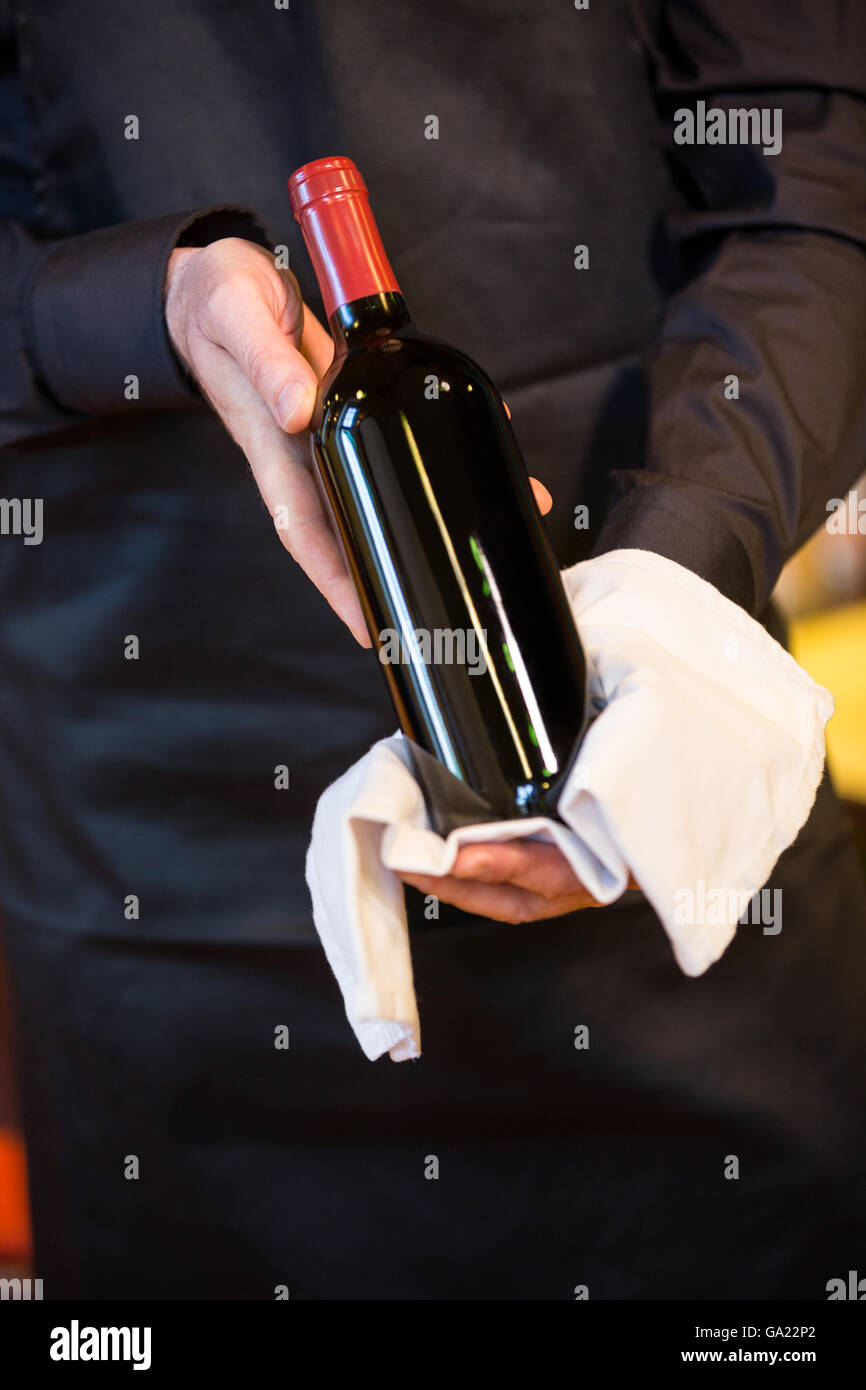 Waiter holding a bottle of red wine Stock Photo