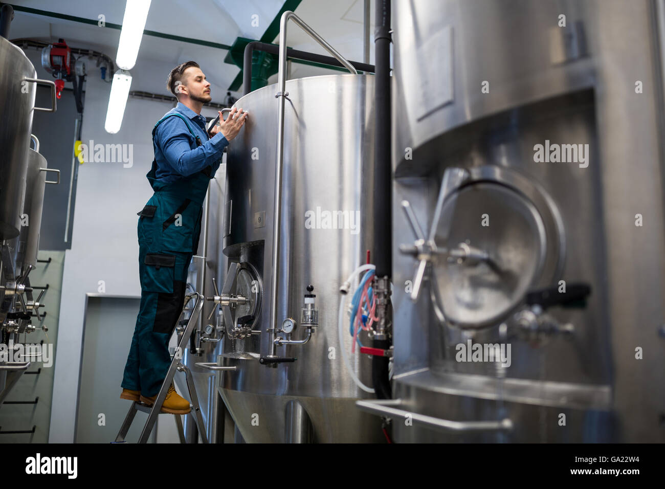 Maintained worker working at brewery Stock Photo