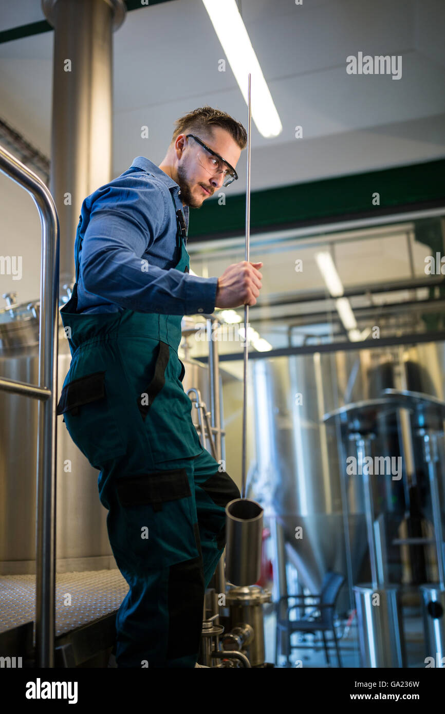 Thoughtful Brewer holding working equipment Stock Photo