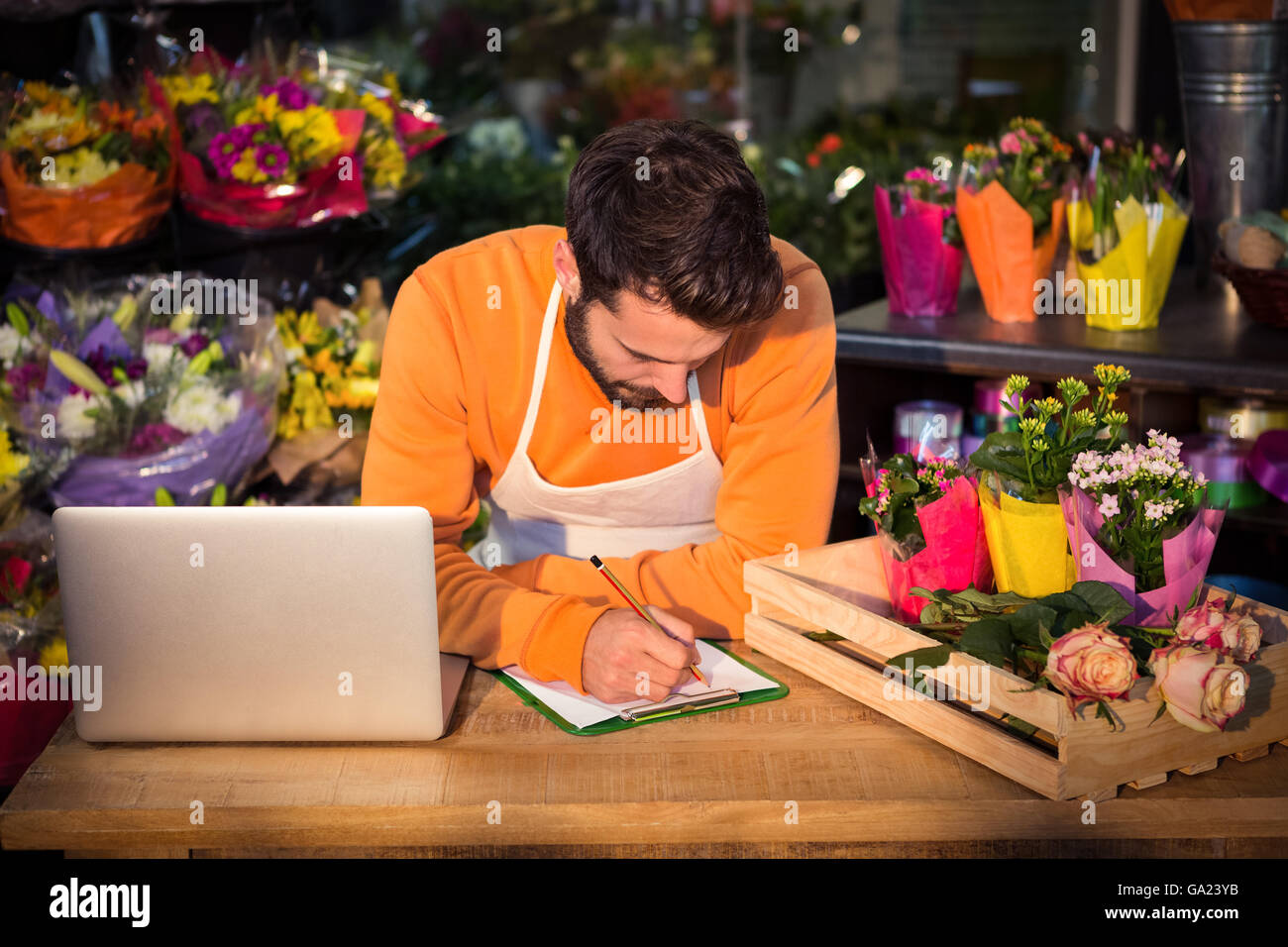 Male florist noting order in notepad Stock Photo