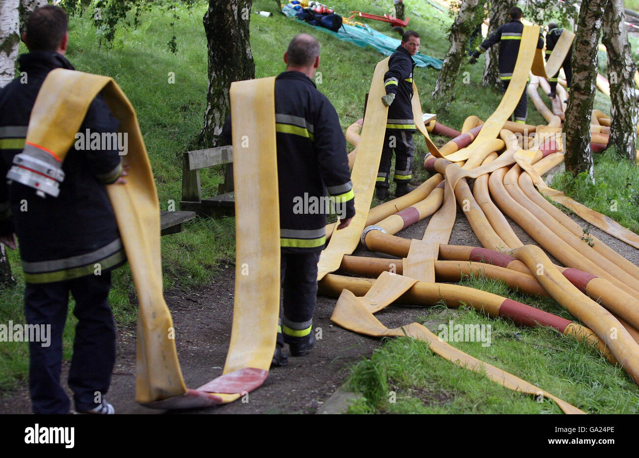 Firefighters lay hoses in an attempt to drain water from behind the