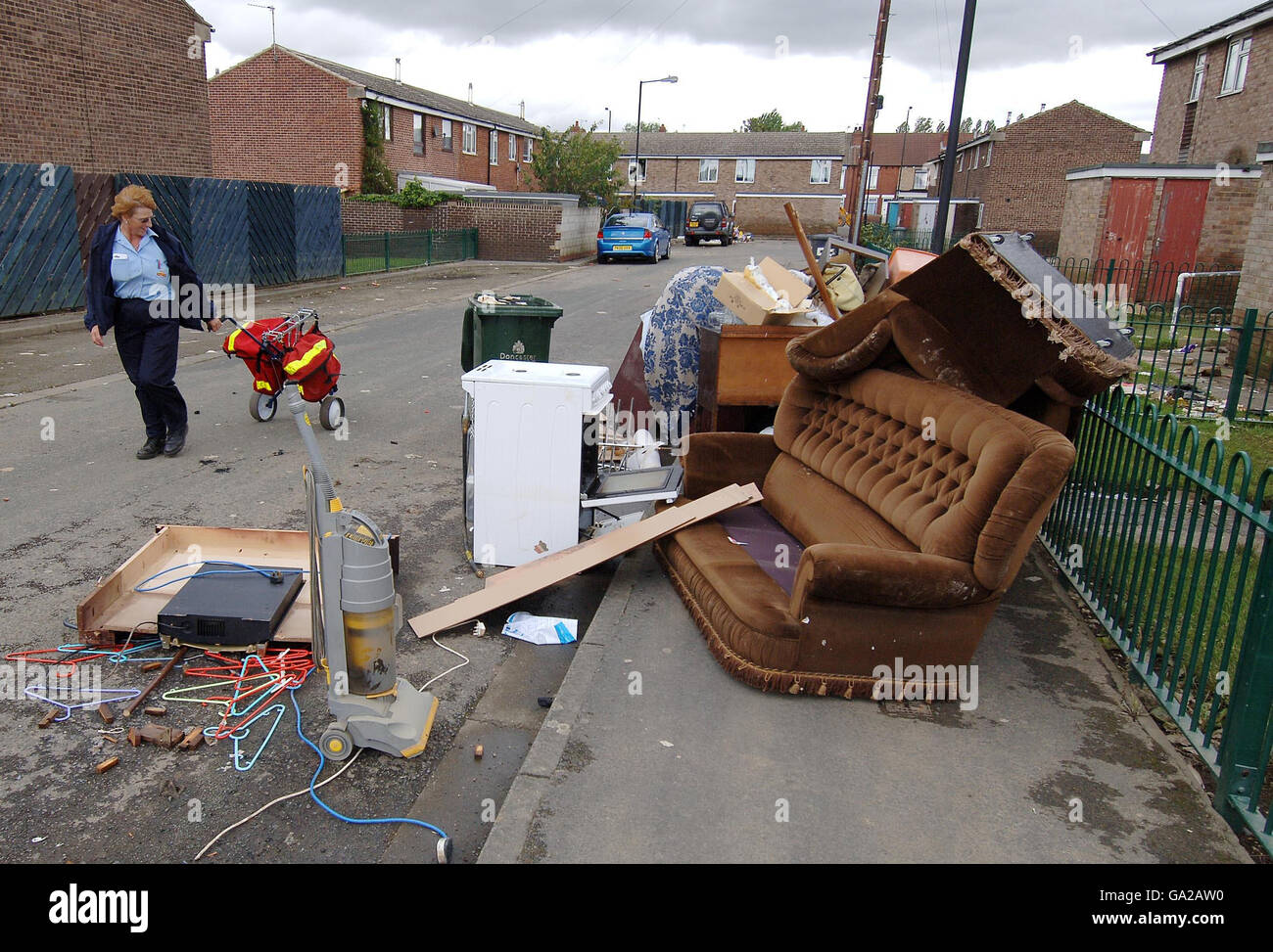A postal worker walks past ruined possessions in Toll Bar, near Doncaster, which was hit by heavy flooding. Stock Photo