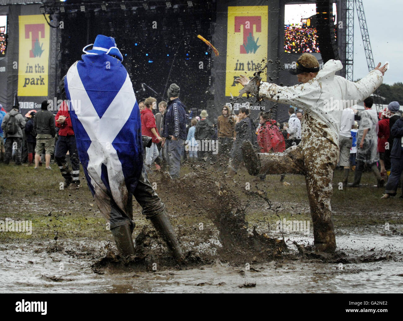 Members of the public dance in a puddle at T in the Park in Balado, Perth and Kinross. Stock Photo