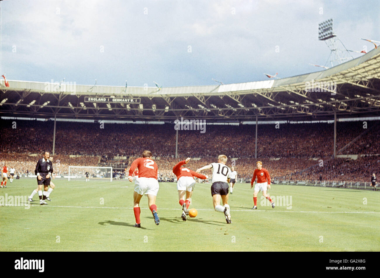 England's Nobby Stiles breaks away from West Germany's Siggi Held as England's George Cohen and Alan Ball look on Stock Photo