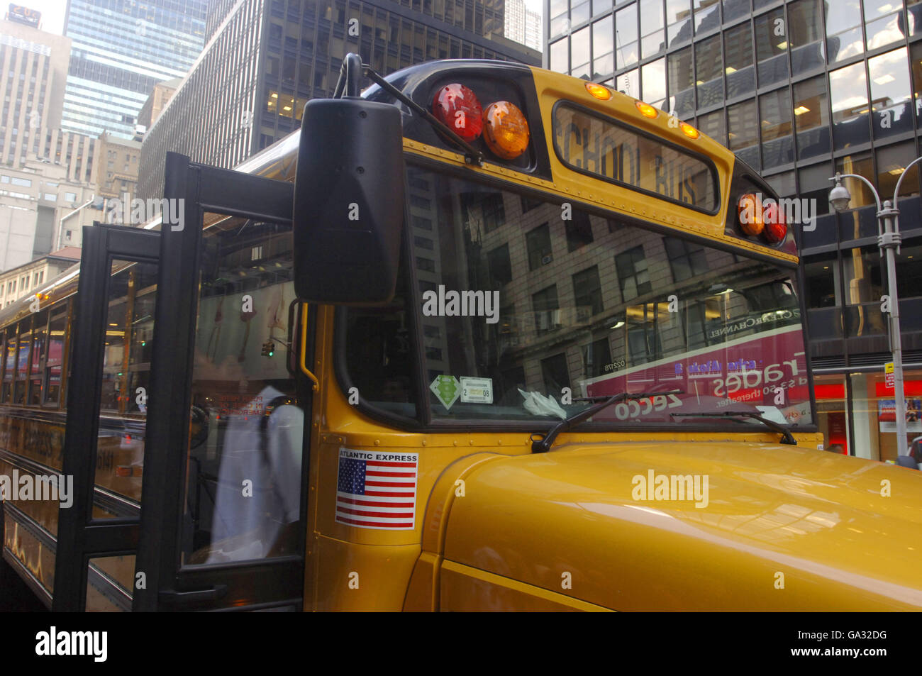 An American School Bus stops to let students out, Midtown, New York. Stock Photo