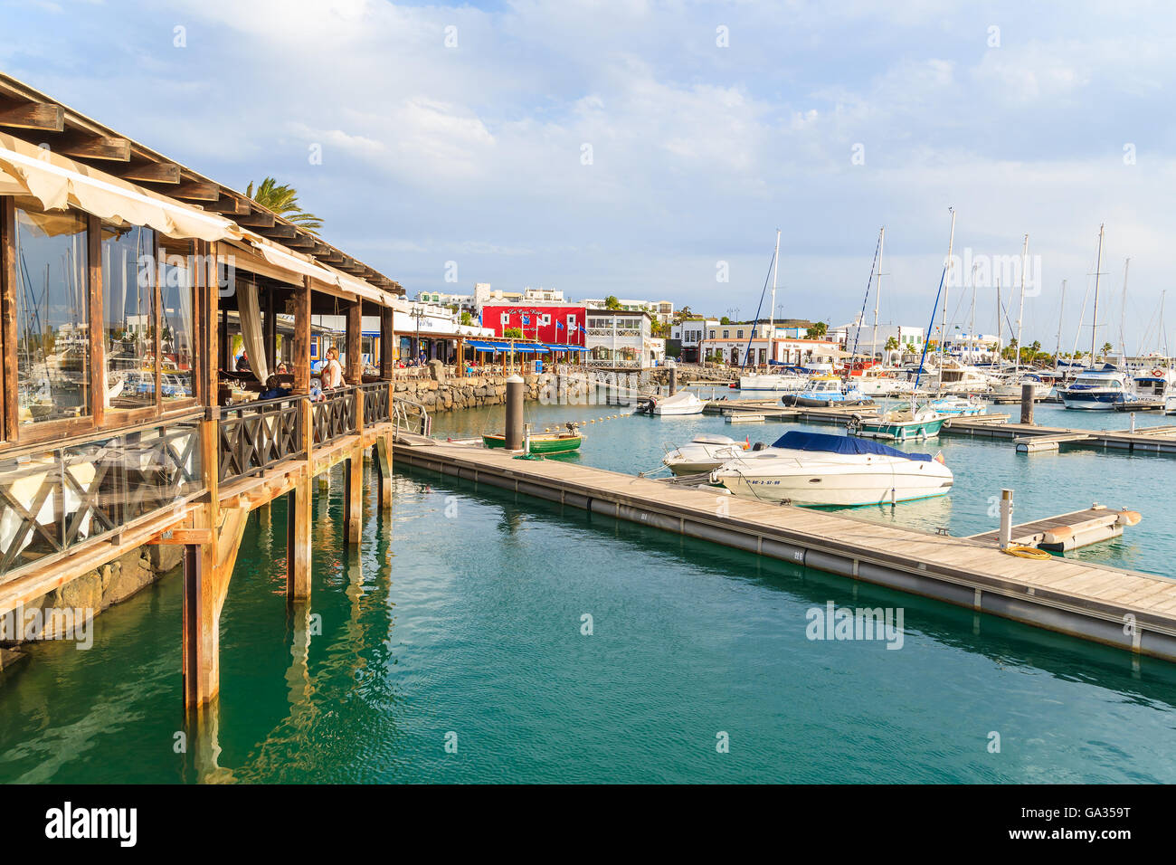 MARINA RUBICON, LANZAROTE ISLAND - JAN 11, 2015: restaurant and pier in Rubicon port, Playa Blanca town. Canary Islands are popular holiday destination due to sunny tropical climate. Stock Photo