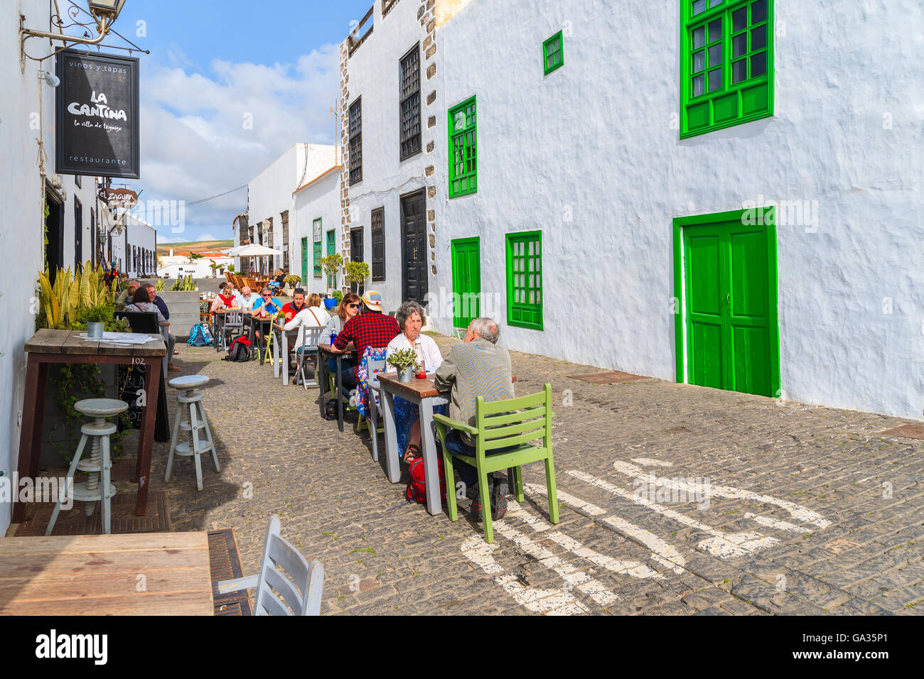TEGUISE TOWN, LANZAROTE ISLAND - JAN 14, 2015: tourists sitting in local restaurant in old town of Teguise. This town is former capital of Lanzarote island and is very popular attraction to see. Stock Photo