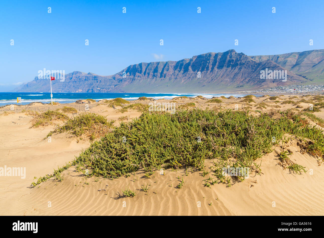 Sand dune on Famara beach with high mountain cliffs, Lanzarote, Canary Islands, Spain Stock Photo