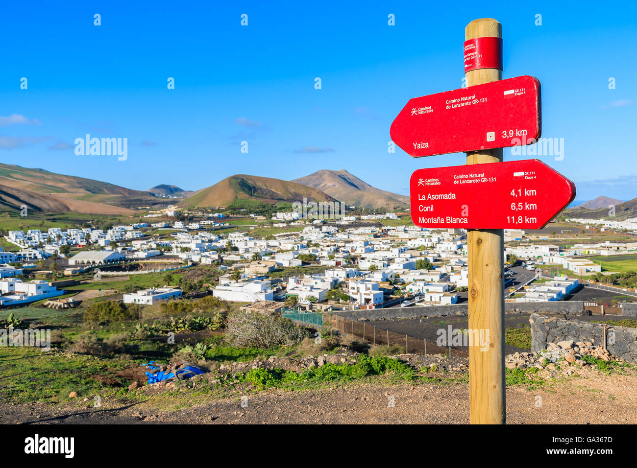 In focus trekking sign with blurred Uga village in background, Lanzarote, Canary Islands, Spain Stock Photo