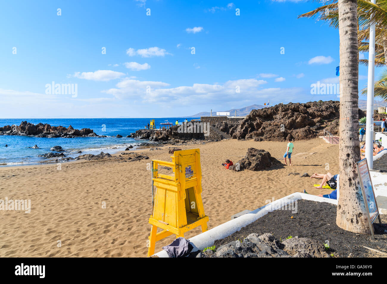 PUERTO DEL CARMEN, LANZAROTE ISLAND - JAN 17, 2015: Yellow lifeguard tower on tropical beach in Puerto del Carmen holiday town. Canary Islands are popular holiday destination all year round. Stock Photo
