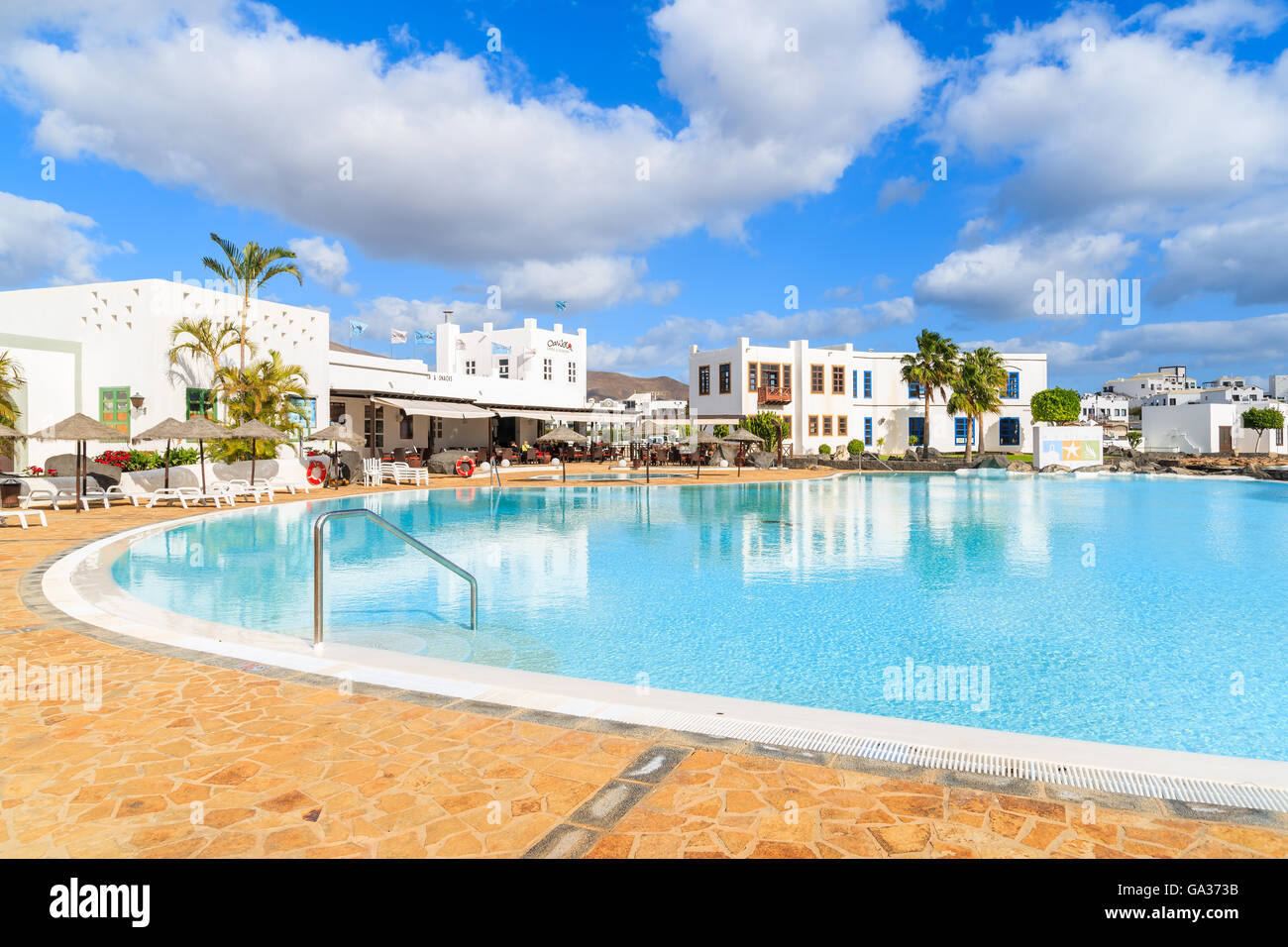 PLAYA BLANCA, LANZAROTE ISLAND - JAN 17, 2015: swimming pool of luxury apartment complex built in traditional Canary style on Lanzarote island. Canary Islands are popular holiday destination. Stock Photo
