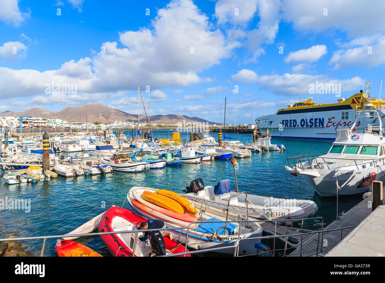 PLAYA BLANCA PORT, LANZAROTE ISLAND - JAN 17, 2015: colourful boats in Playa Blanca harbour on sunny day. Lanzarote is very popular tourist destination among Canary Islands archipelago. Stock Photo