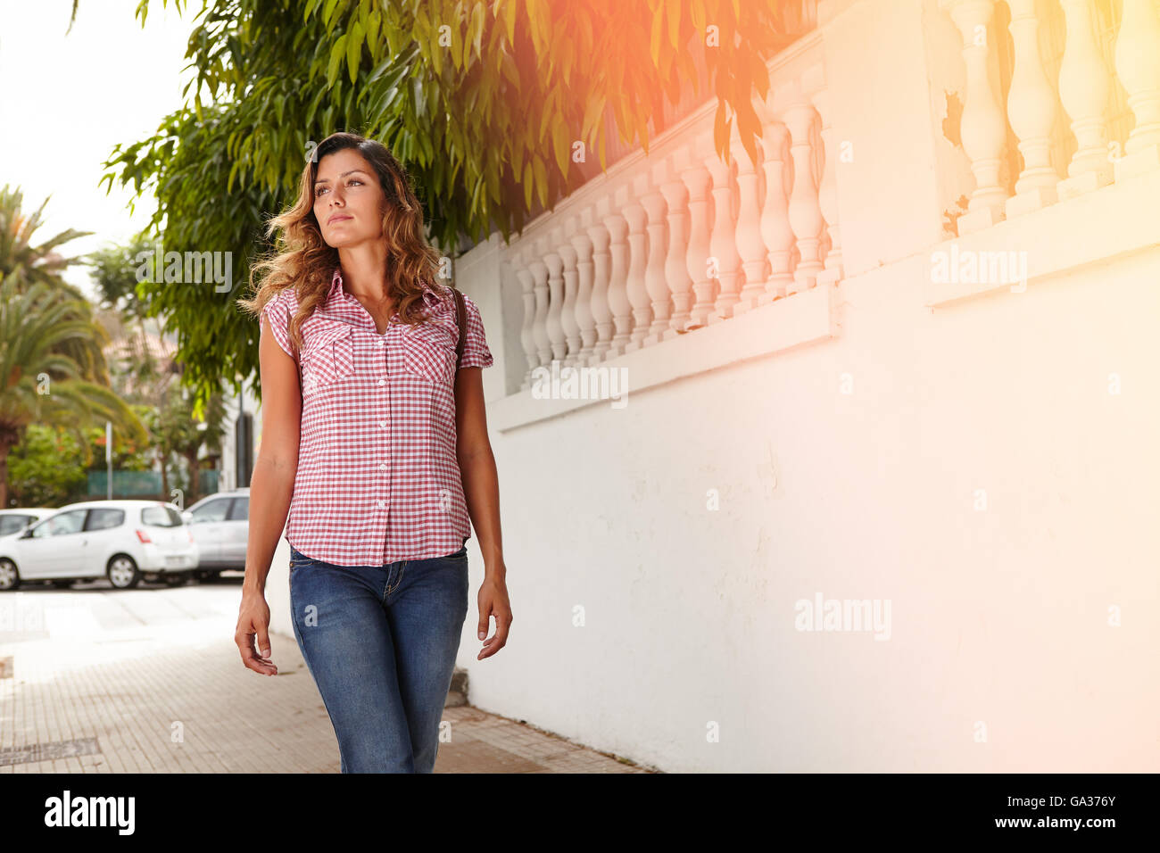 Young woman 20-24 years old looking away while walking outdoors - copy space Stock Photo