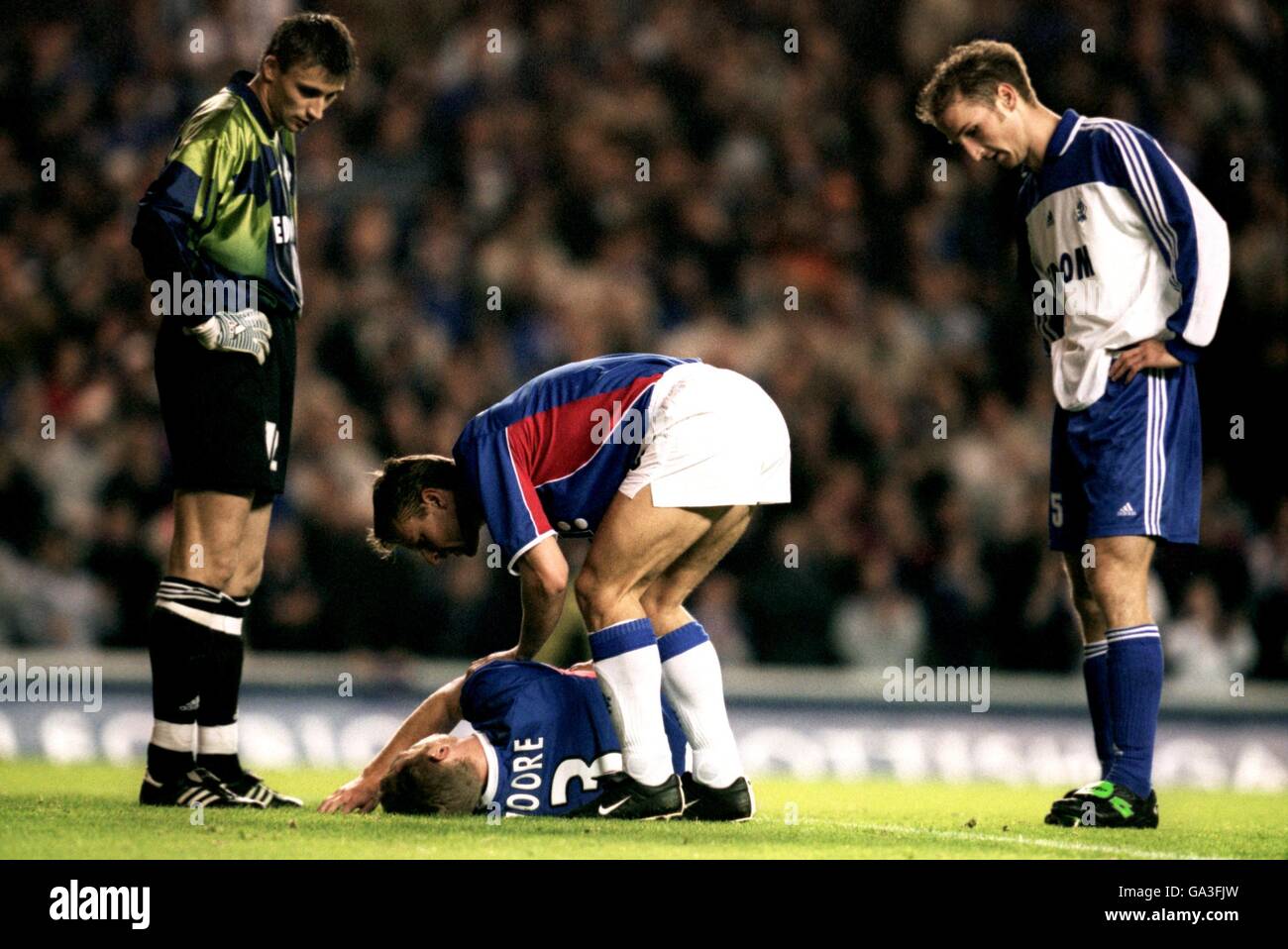 Rangers' Craig Moore lies injured on the floor as his teammate Arthur Numan checks his condition whilst Dinamo Moscow's Darius Zutautas (r) and goalkeeper Vasily Khonutovsky (l) look on Stock Photo