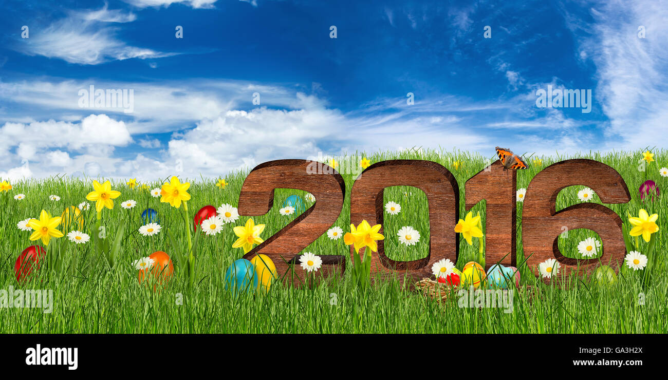 wooden 2016 lettering in easter meadow in front of blue sky Stock Photo