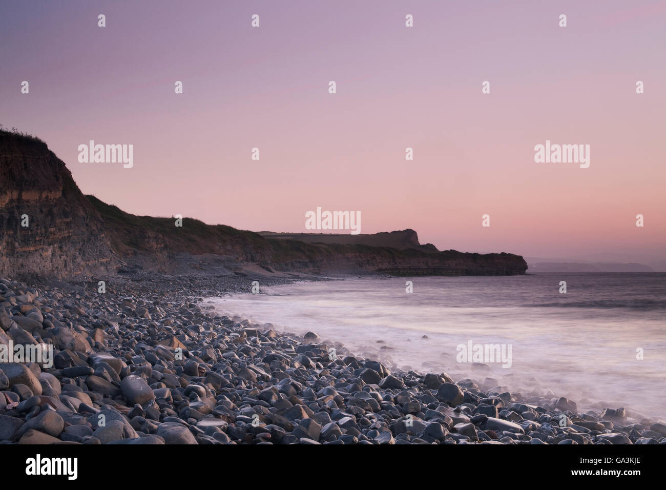 Kilve Beach after sunset, with waves washing over the loose rocks, Somerset, England, United Kingdom, Europe Stock Photo