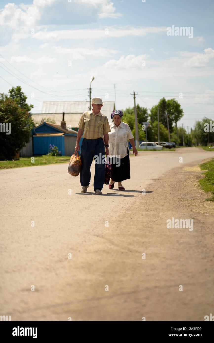 Old couple Walking on a  Road in summer Stock Photo