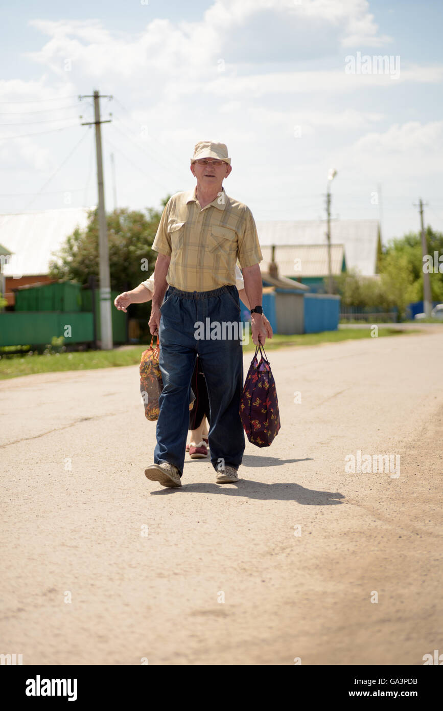 Old couple Walking on a  Road in summer Stock Photo