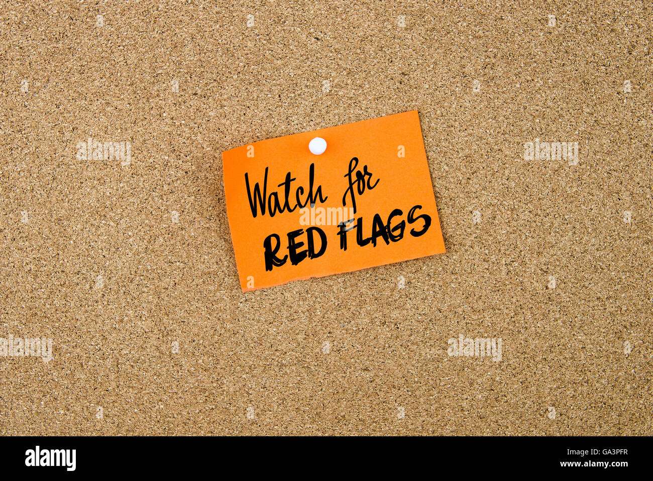 Watch For Red Flags written on orange paper note note pinned on cork board with white thumbtack, copy space available Stock Photo