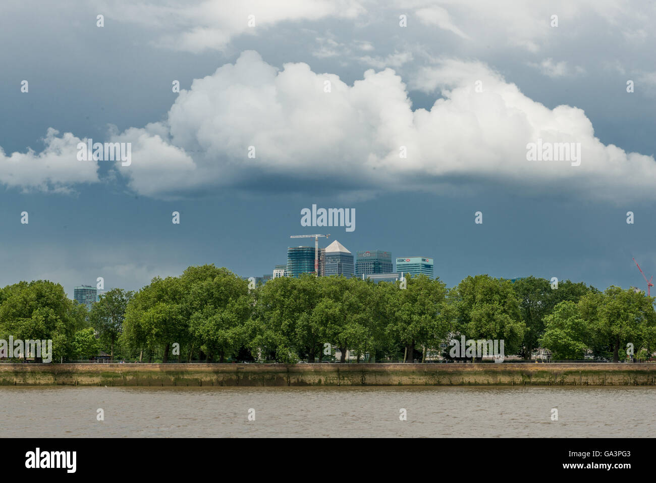 London, United Kingdom - June 25, 2016: View from Greenwich over Canary Wharf: skyscrapers, trees and moody clouds Stock Photo