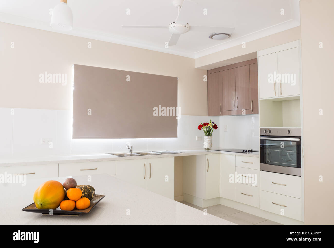 New modern white open plan kitchen with tiled splash back Stock Photo