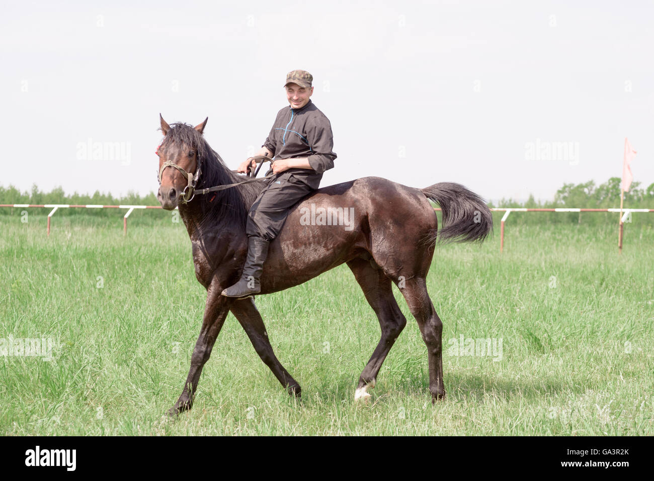 Man riding a brown horse outside without a saddle or safety hat Stock Photo