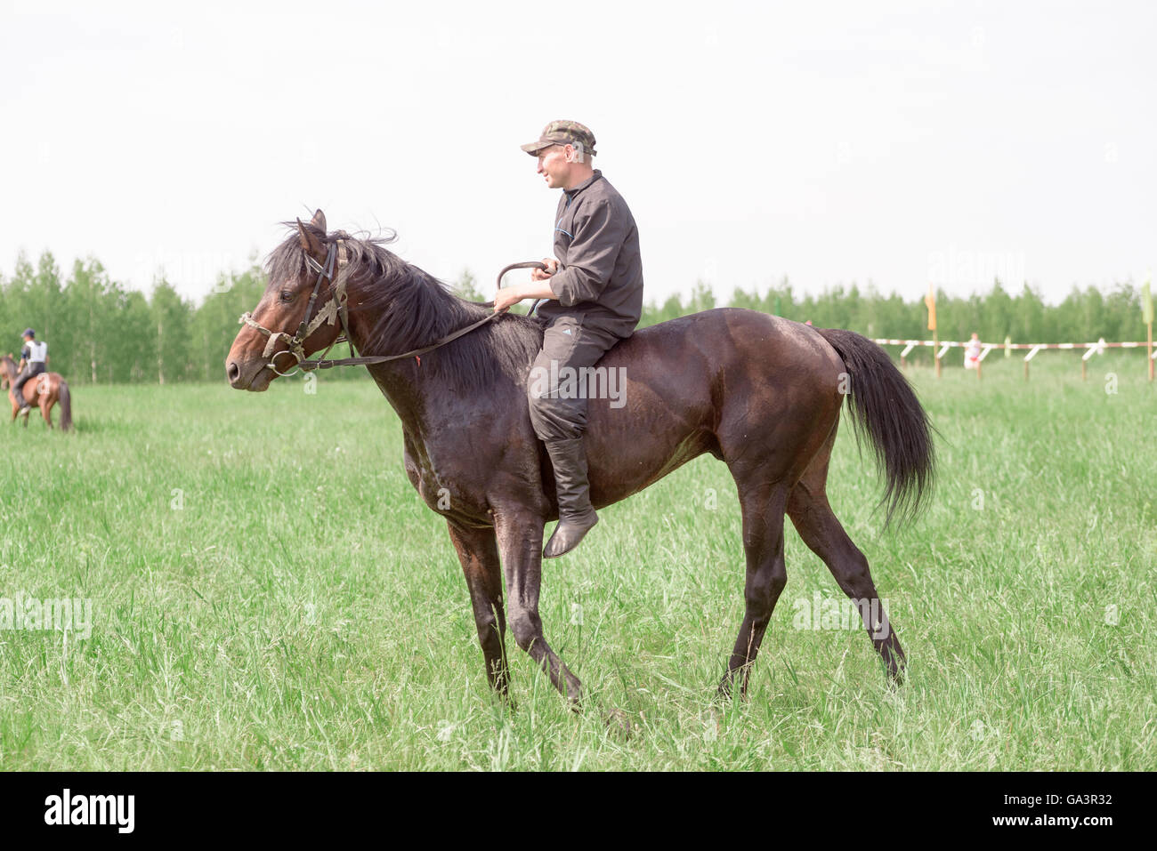 Man riding a brown horse outside without a saddle or safety hat Stock Photo
