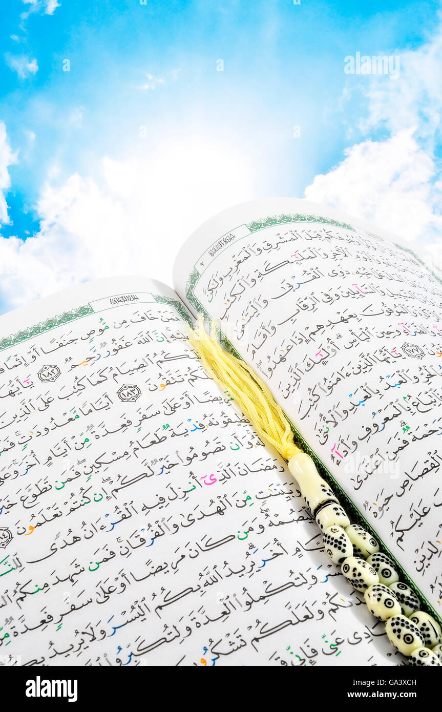 Heaven's Holy Quran With Rosary over Blue Sky Stock Photo