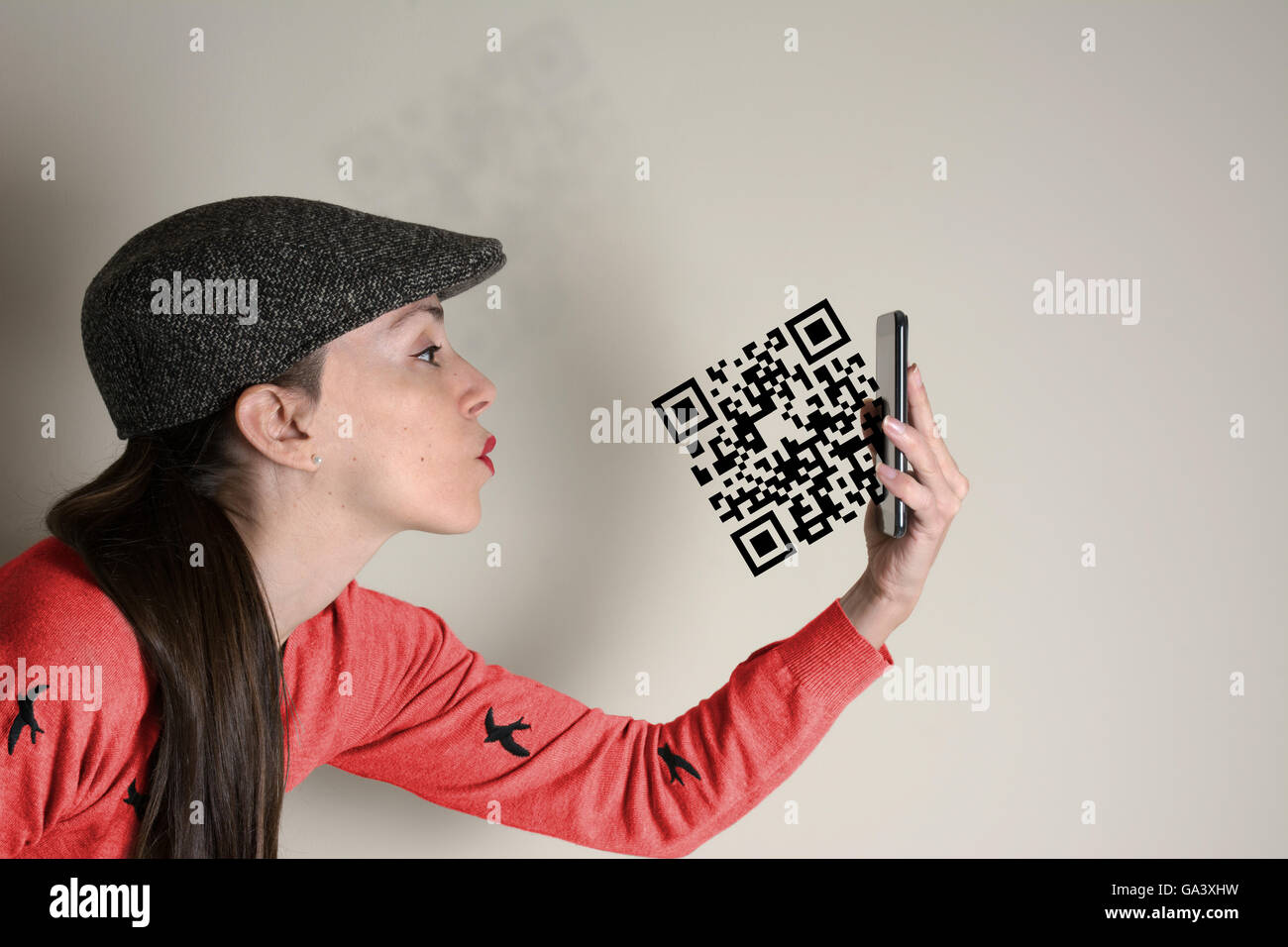 Qr code, woman sends a kiss, the symbol leaving the mobile screen, conceptual idea Stock Photo