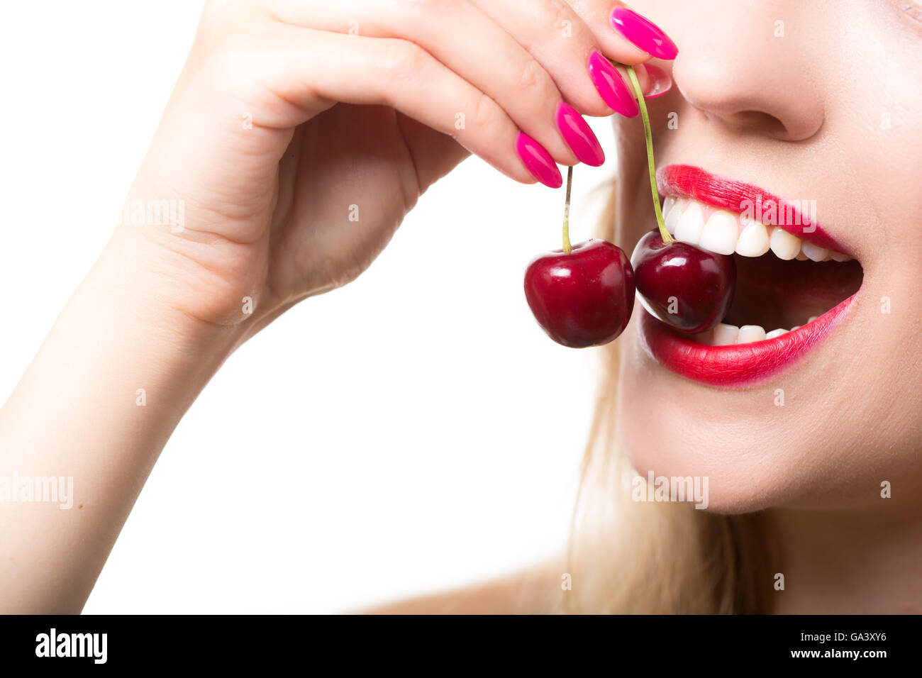 girl's lips and tongue licking two berries Stock Photo