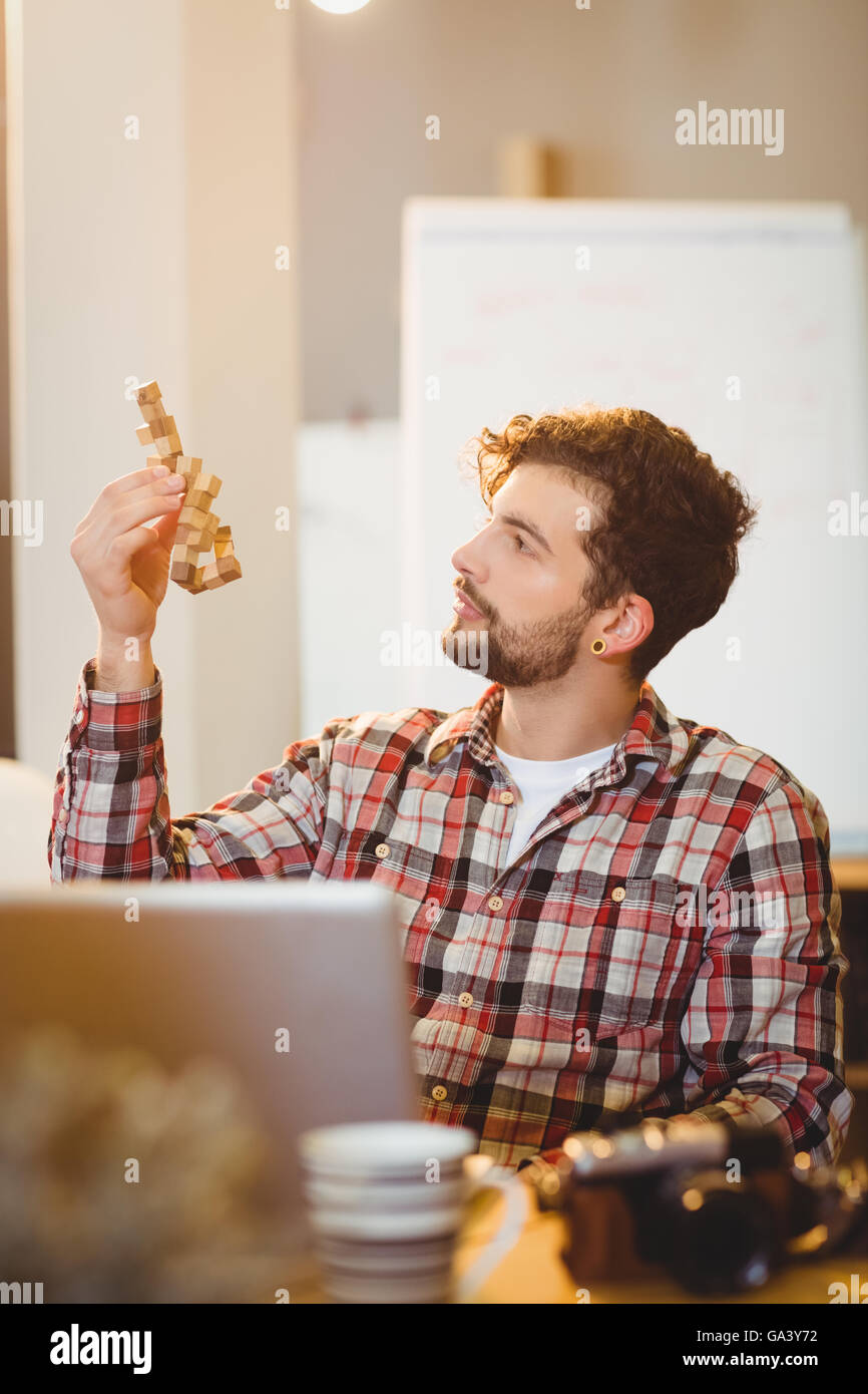 Thoughtful graphic designer looking at wooden block Stock Photo - Alamy