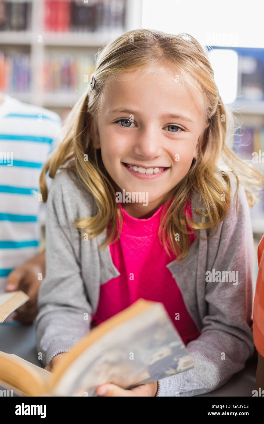 Schoolgirl reading a book in library Stock Photo - Alamy